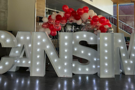 CAN-sim conference sign with lights and balloons