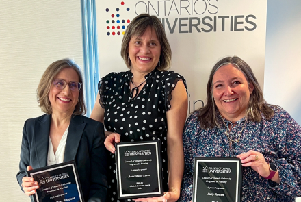 group shot of Dr. Martha Whitfield, Anne Marie Levac and Patty Jansen standing side by side in semi-formal dress, smiling into the camera and holding up their award plaques