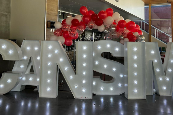 CAN-sim conference sign with lights and balloons