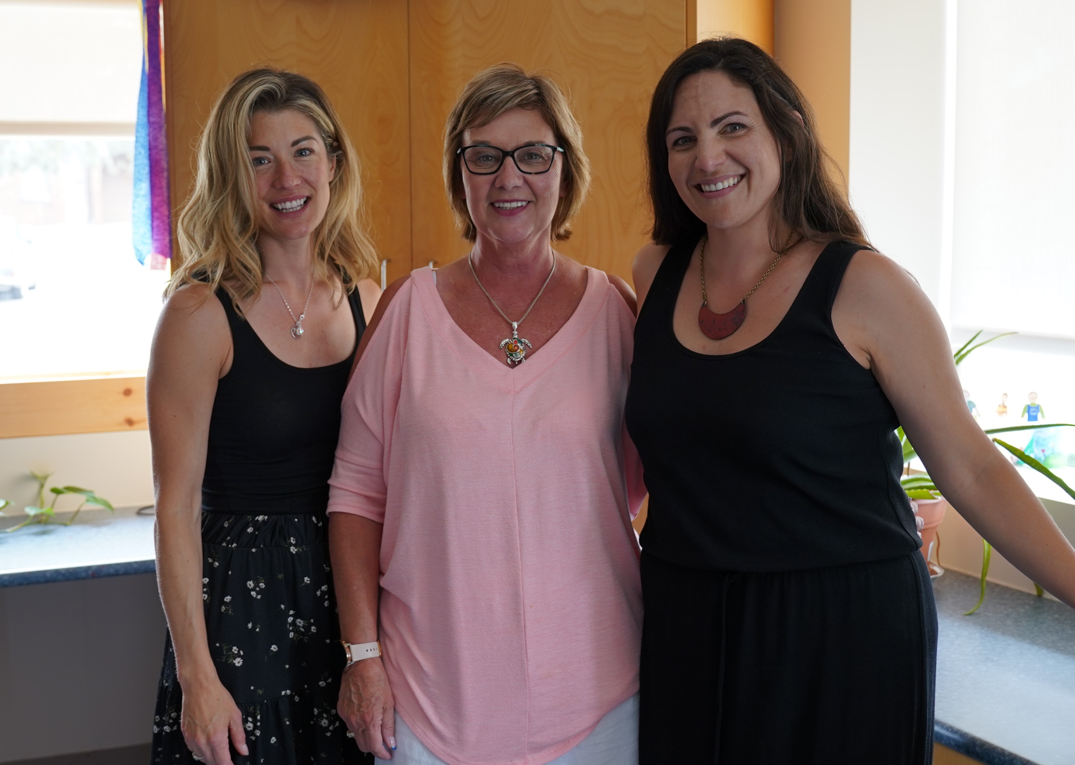 Group photo of Ellie Lambert and Jenna Sands standing and smiling with Recovery College peer-support facilitator Beverly Johnson.